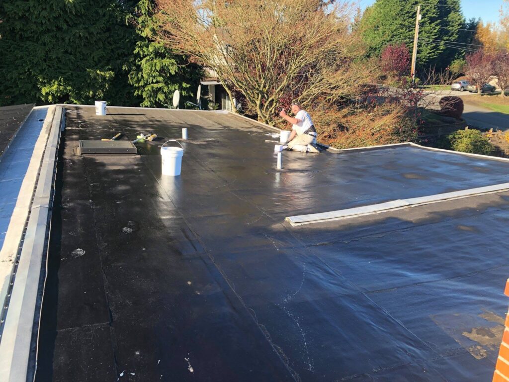 Protective coating application on a flat roof in Western Washington