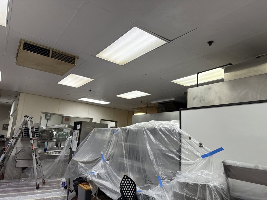Commercial kitchen equipment covered and protected during surface preparation